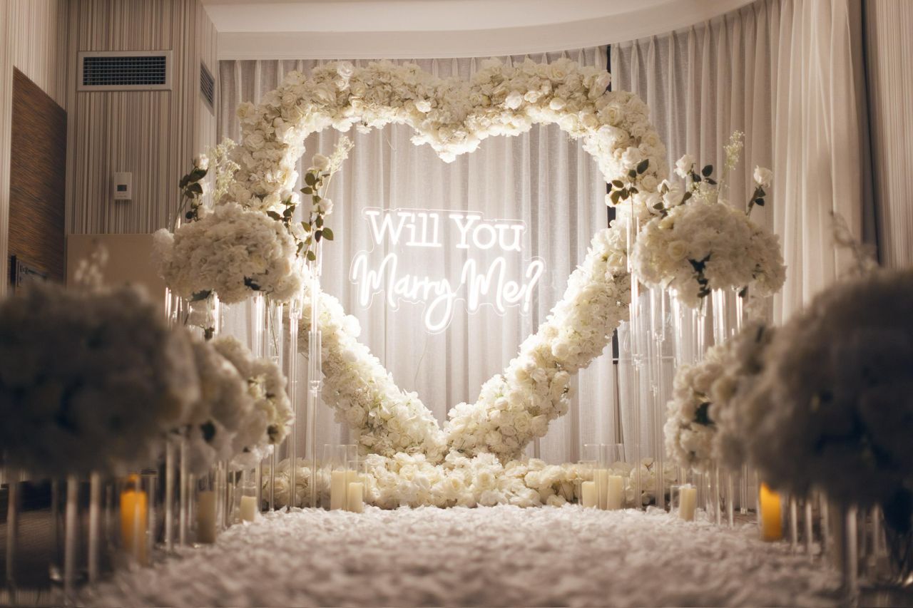 Will You Marry Me neon framed by a white floral heart